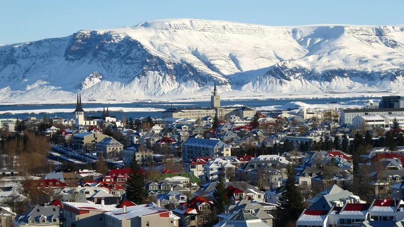 The coloured rooftops of Reykjavik below a snow-capped mountain