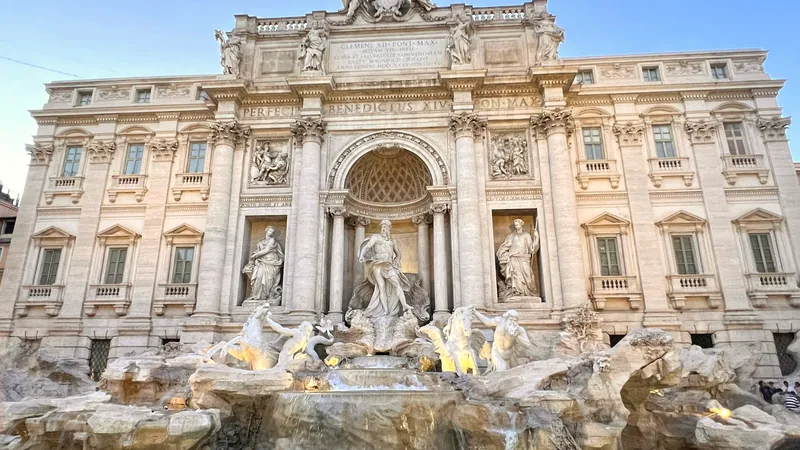 The sculpted facade of the Trevi Fountain above its turquoise basin