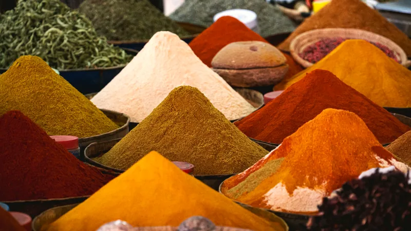 Cones of brightly coloured ground spices at a market stall
